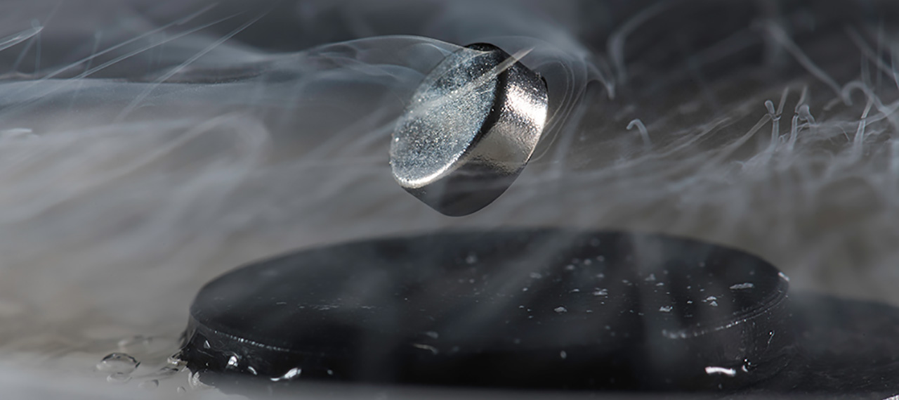 A magnet floats above a superconductor cooled with liquid nitrogen.